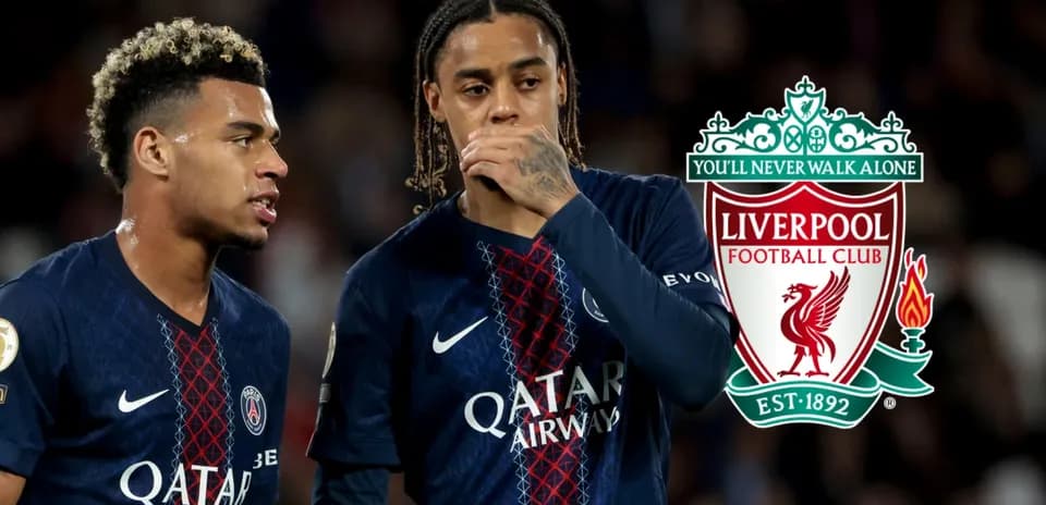 Two players in PSG jerseys discussing on the field