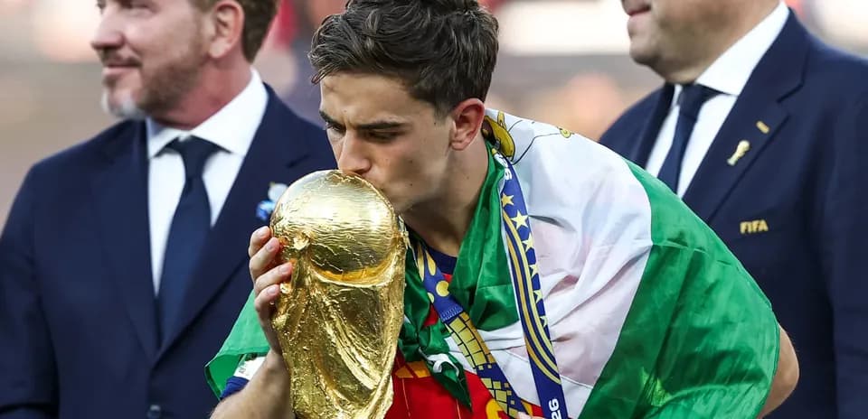 Player kissing World Cup trophy wearing national flag
