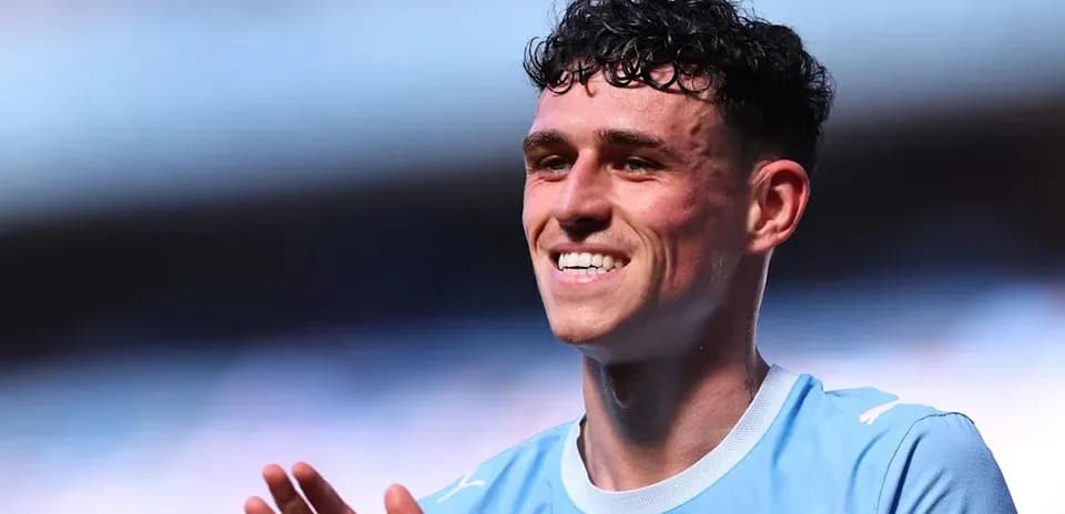 Player smiling and applauding in light blue jersey