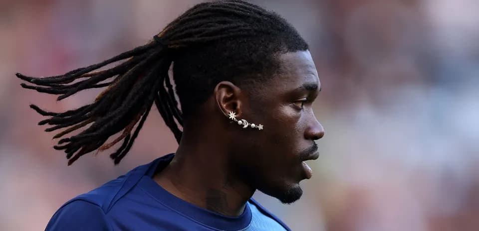 Player with dreadlocks and unique earring on field