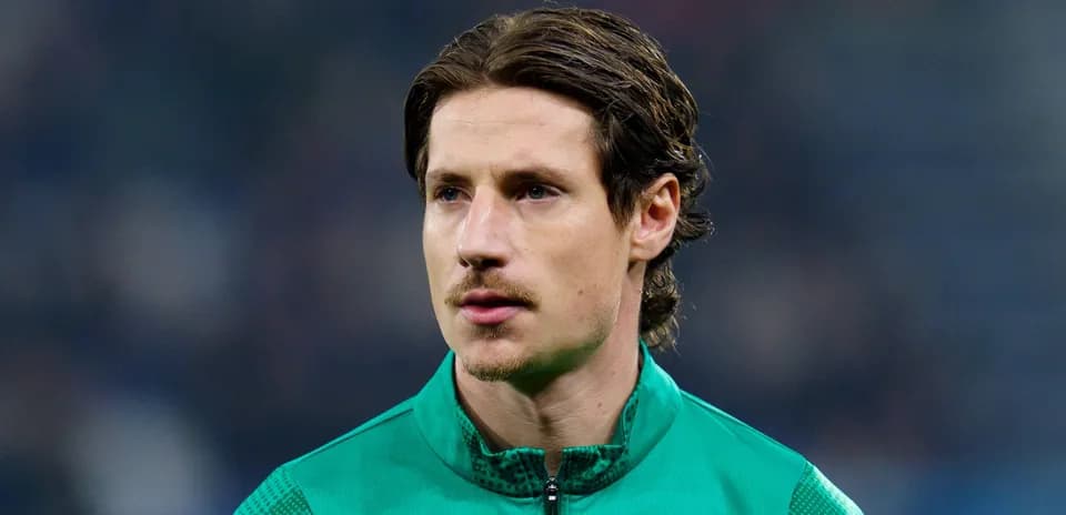 Goalkeeper in green jersey during pre-match warm-up