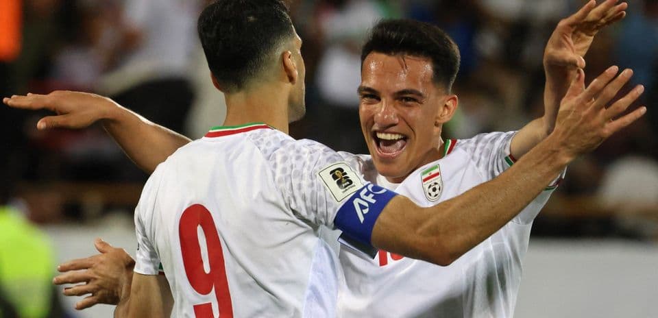 Two players celebrating a goal on the field