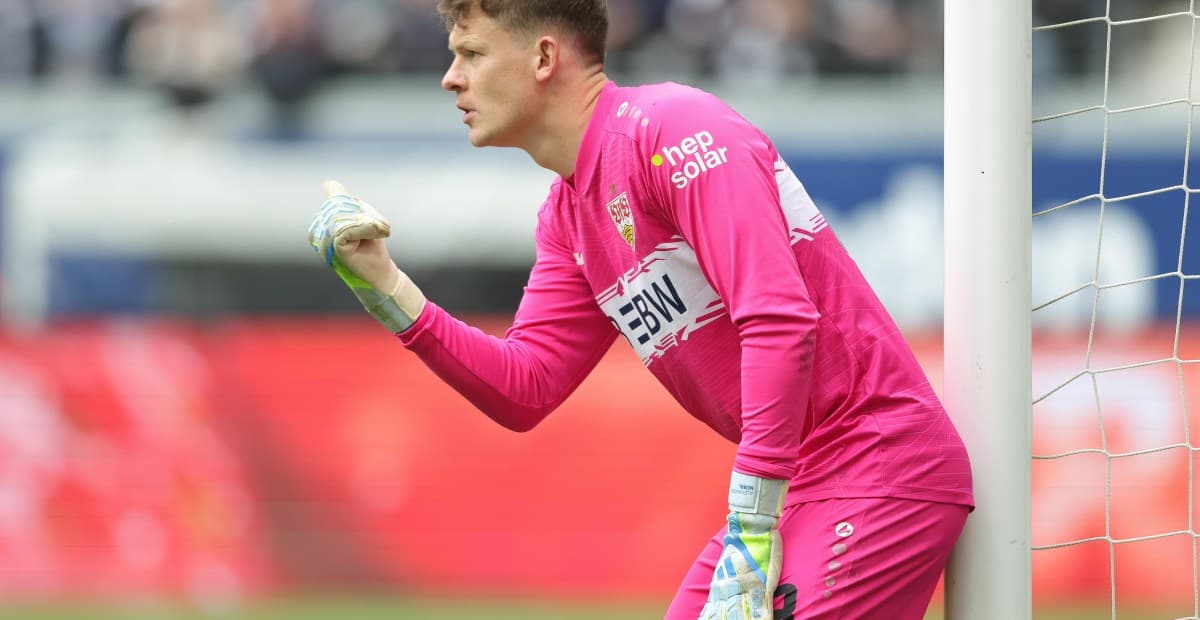 Goalkeeper in pink uniform signaling during match