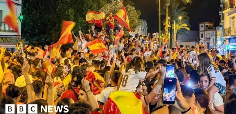 Crowd celebrating with flags in a street