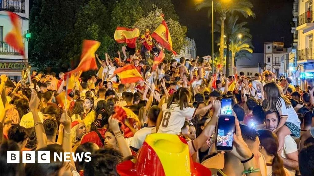 Crowd celebrating with flags in a street