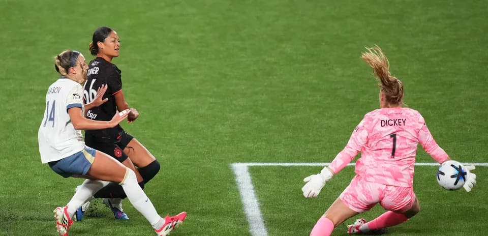 Portland Thorns W player challenging Houston Dash W goalkeeper