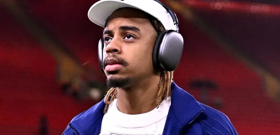 Player walking with headphones at stadium entrance