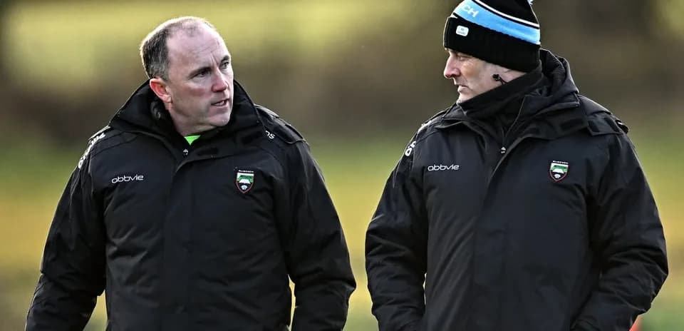 Two coaches discussing strategies on training field
