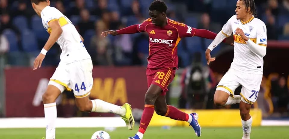 Player dribbling past two defenders during match