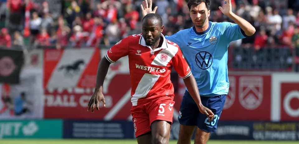Cavalry FC player dribbling past HFX Wanderers FC opponent
