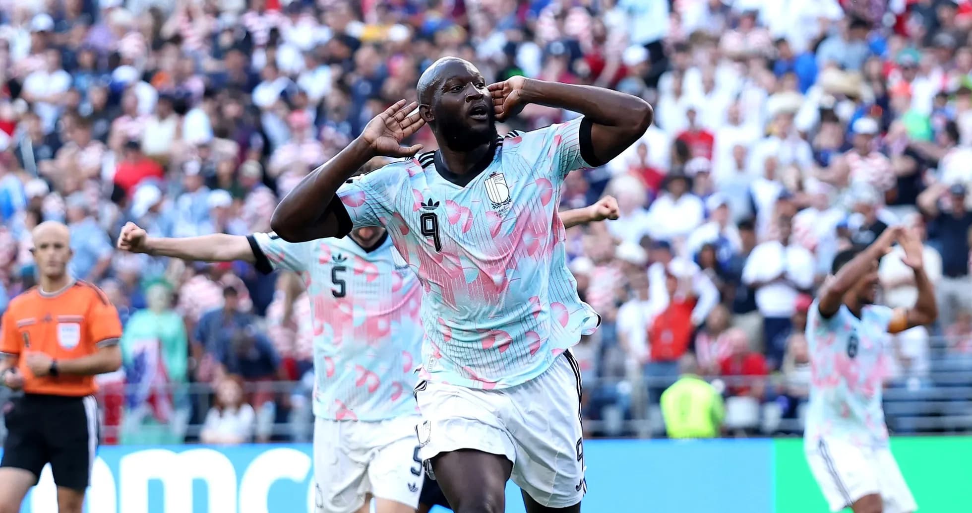 Player celebrating goal with teammates in stadium