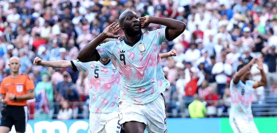 Player celebrating goal with teammates in stadium
