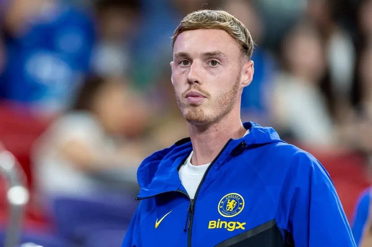 Player in Chelsea jacket on sidelines during match