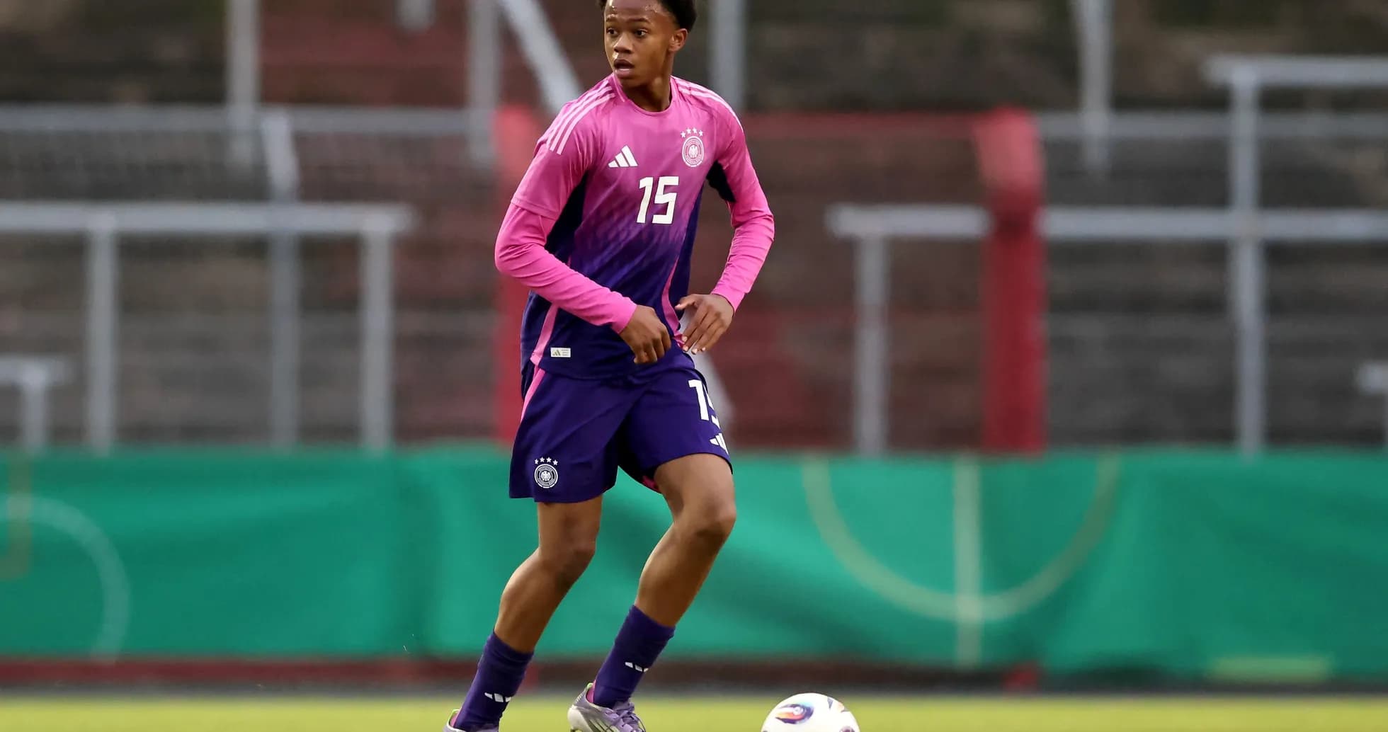 Player in pink and purple kit during training session