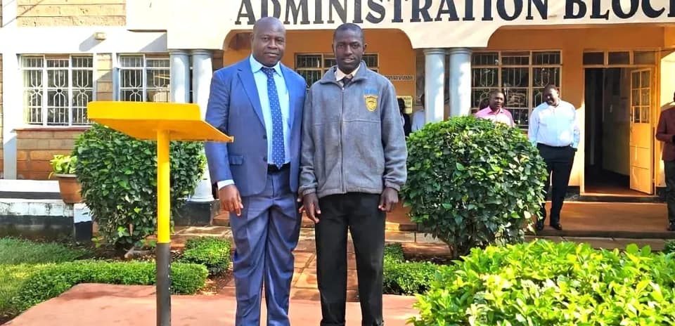 Two men posing in front of school building