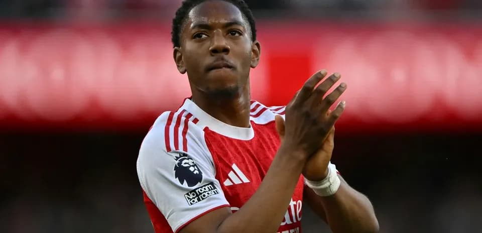Player applauding fans in Arsenal kit at stadium