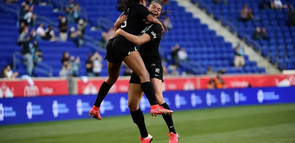 Players celebrating a goal during NWSL match