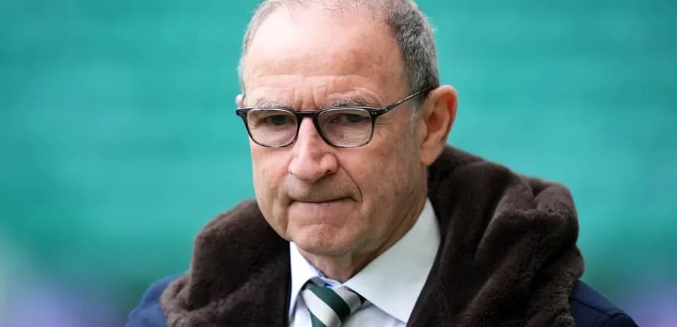 Man in glasses wearing a coat at stadium
