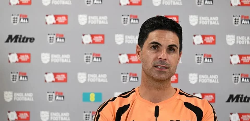 Manager speaking at press conference with logos behind