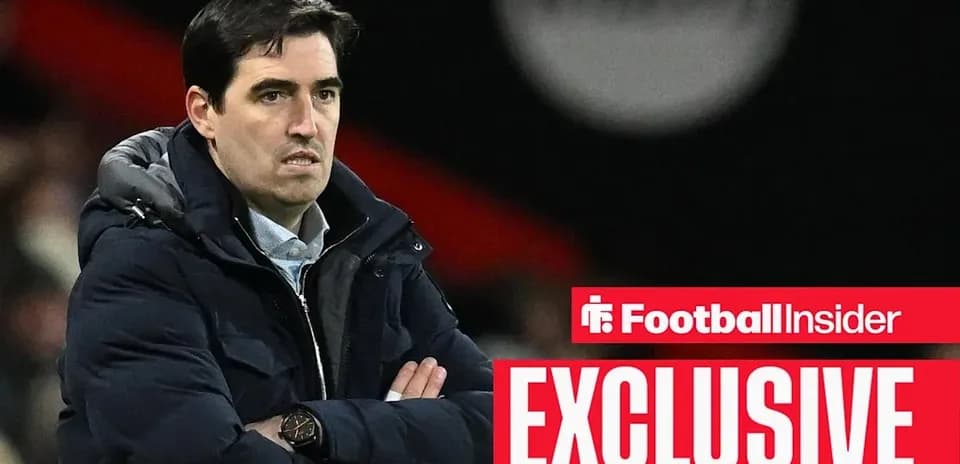 Manager observing match with arms crossed on sidelines
