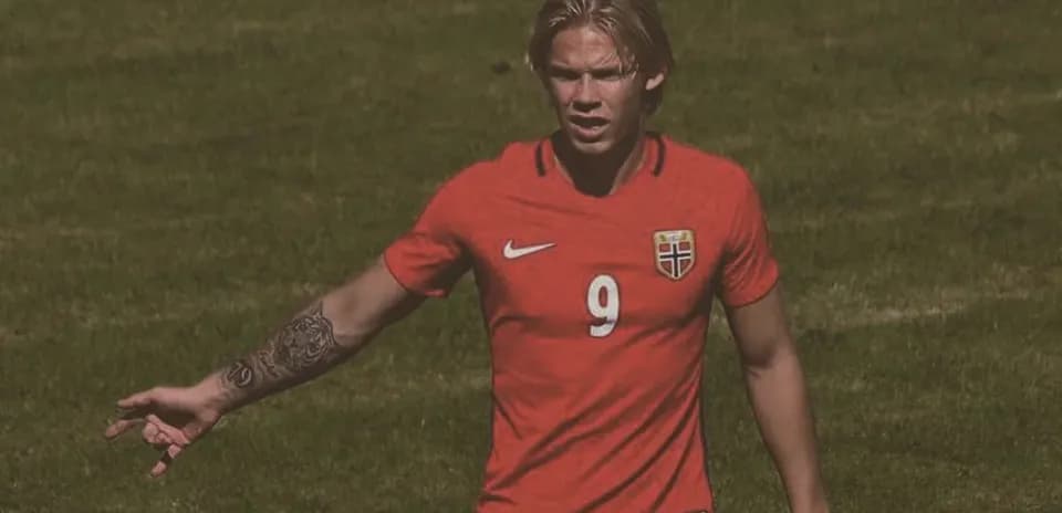 Player in red Norway jersey gesturing on field