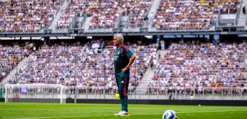 Coach observing match from sideline in stadium