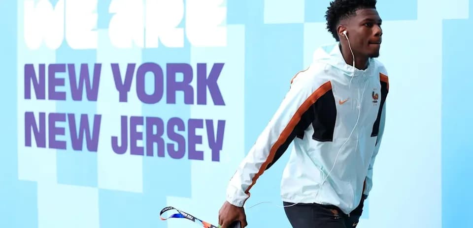 Player walking past 'We Are New York New Jersey' sign