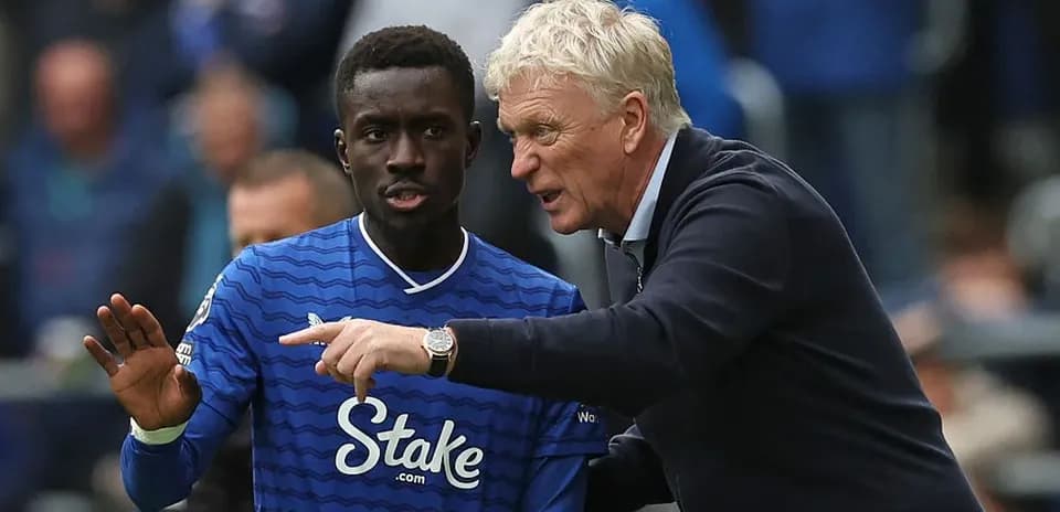 Manager giving instructions to player on pitch