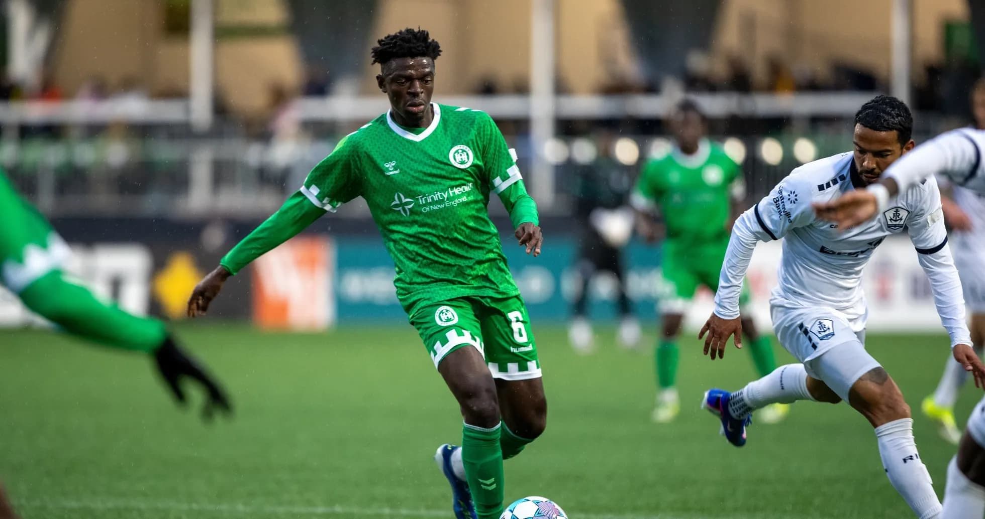 Player in green jersey dribbling during match