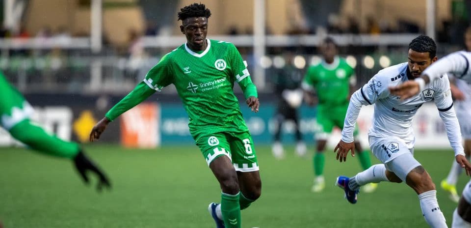 Player in green jersey dribbling during match