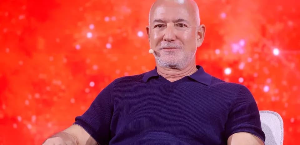 Person seated on stage with red background