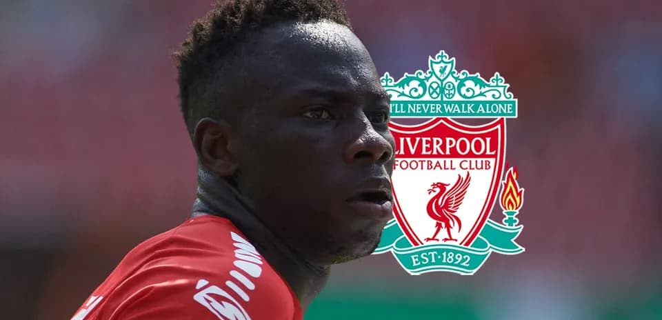 Player in Liverpool jersey with club logo background