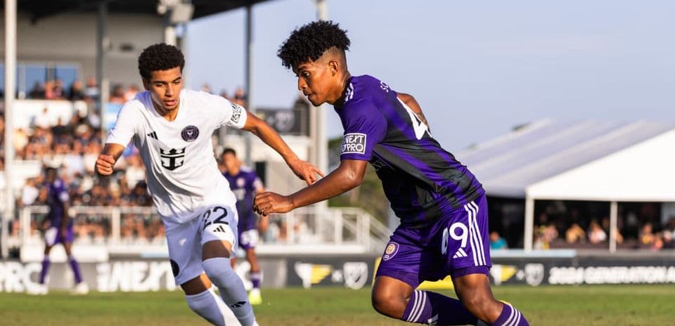 New England II player tackling Orlando City II forward
