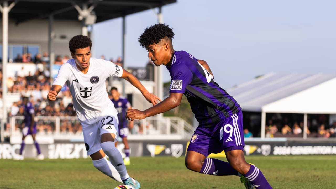 New England II player tackling Orlando City II forward