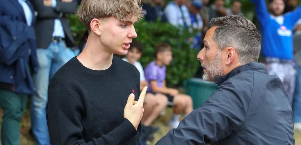 Two men discussing intently near a crowd