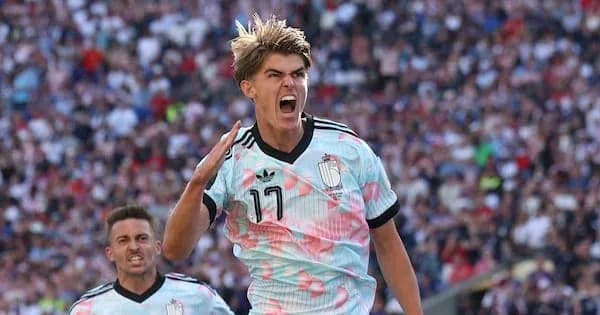 Player celebrating a goal with teammates in stadium