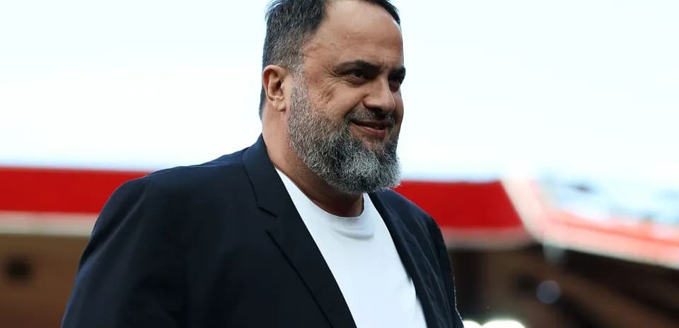 Man in suit walking at a sports venue