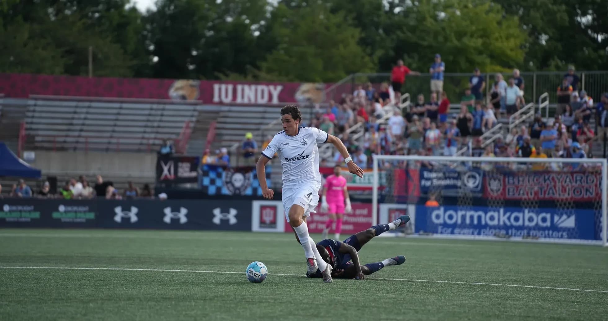 Player evading tackle during Rhode Island match