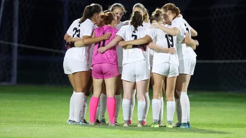 Soccer team huddled together on field