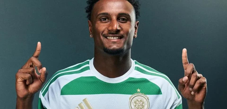 Player posing in Celtic FC jersey with fingers raised
