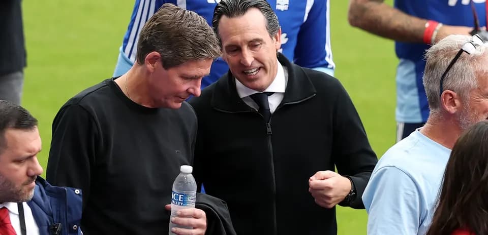 Two men talking on the pitch before a match