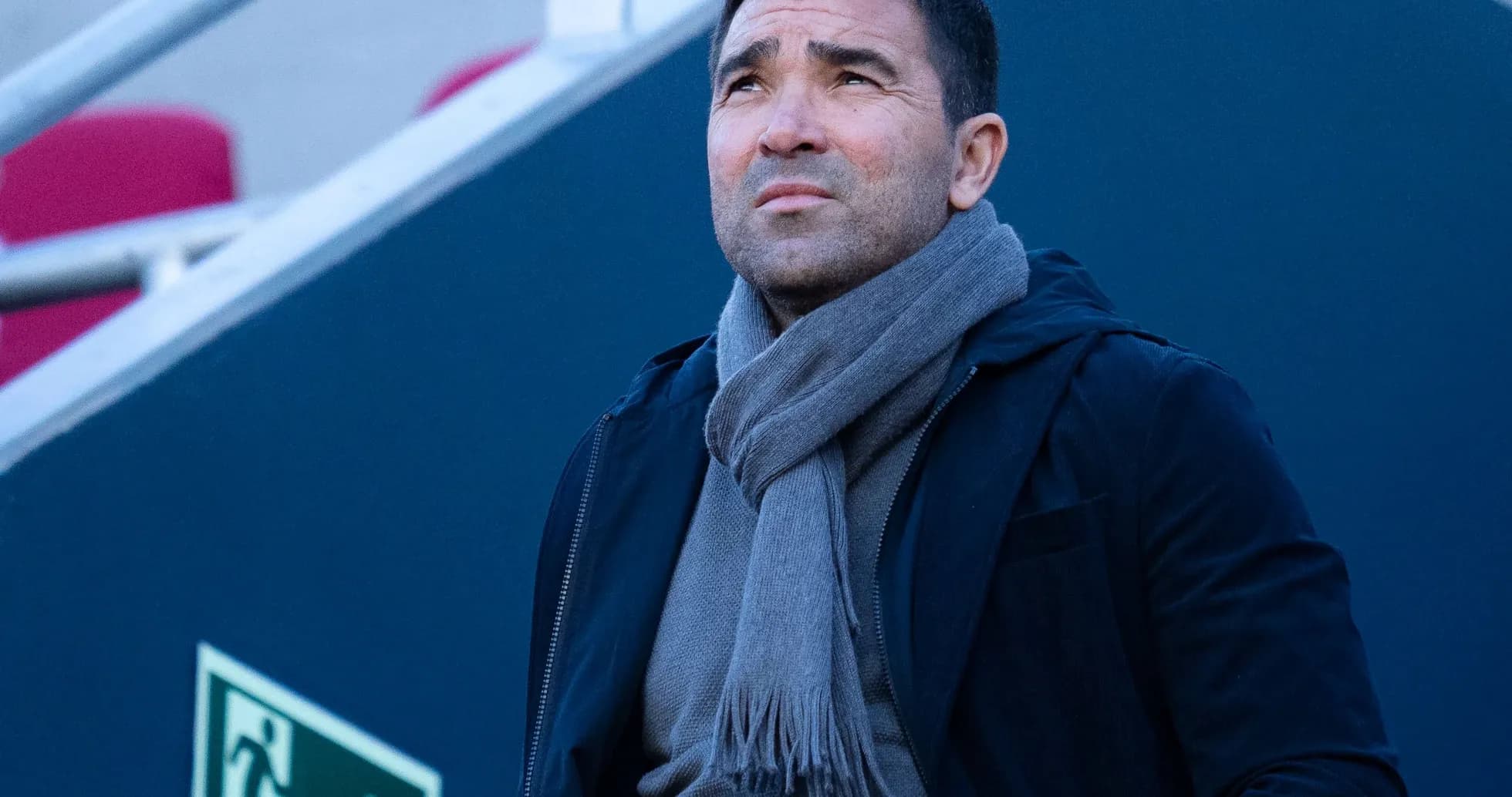 Man in dark coat and scarf looking upwards