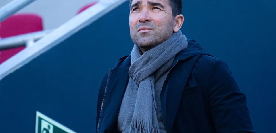 Man in dark coat and scarf looking upwards