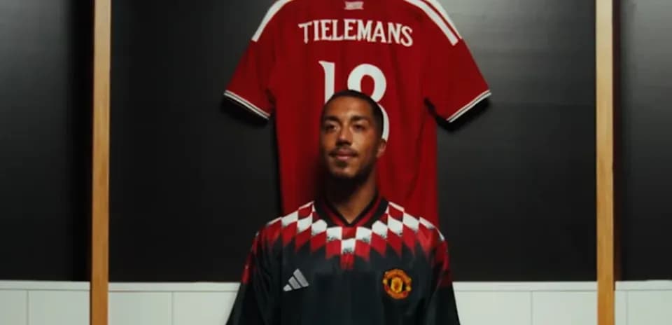 Player posing in Manchester United jersey with another jersey
