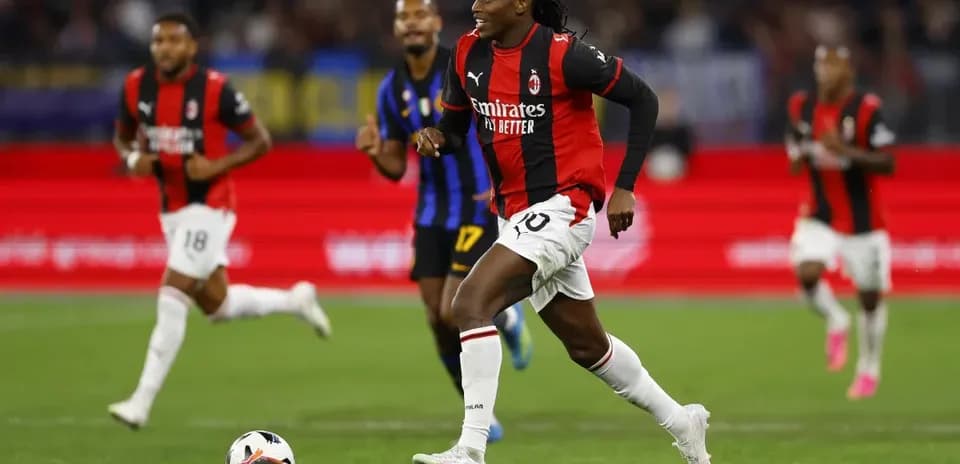Player in AC Milan jersey running with the ball