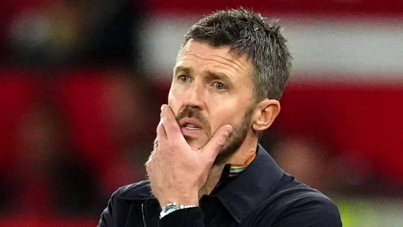 Coach pondering during a match on the sidelines