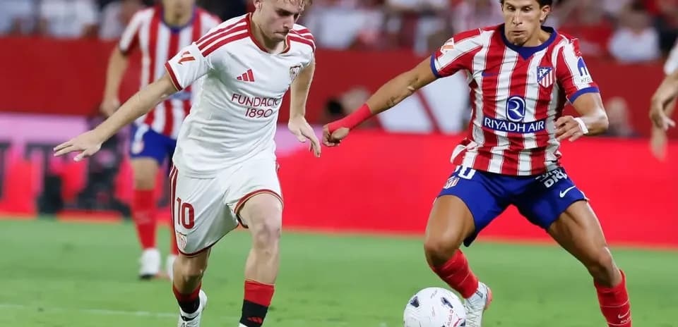 Sevilla player dribbling against Atletico Madrid