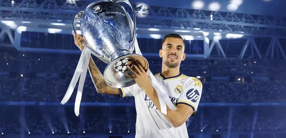 Player holding UEFA Champions League trophy on stage