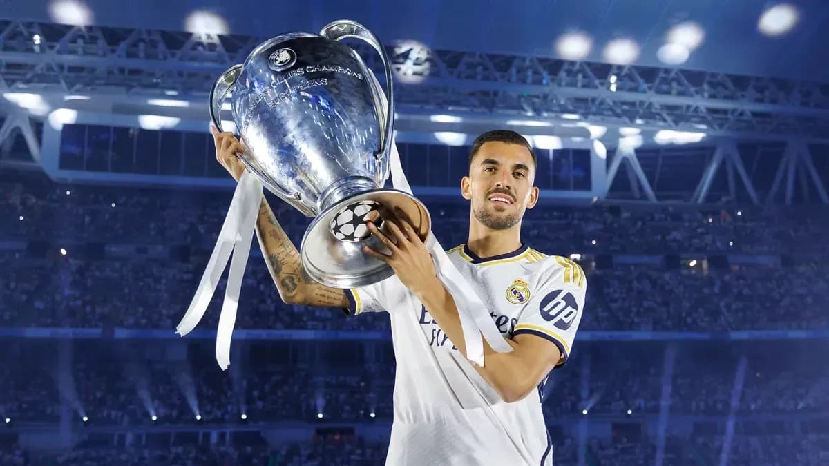Player holding UEFA Champions League trophy on stage