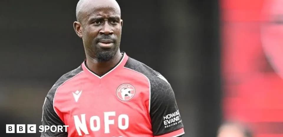 Player in red and black jersey during match warm-up